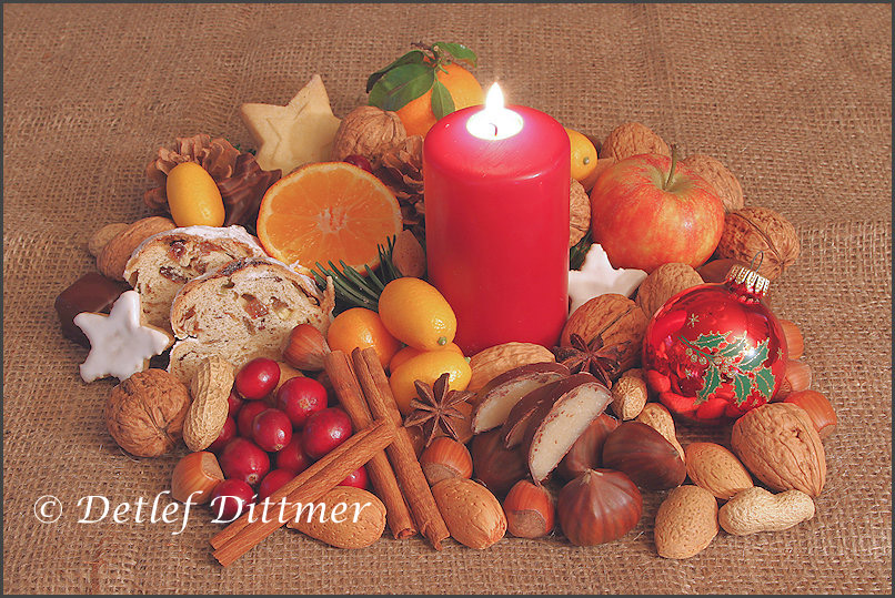 Arrangement zur Weihnachtszeit mit brennender Kerze